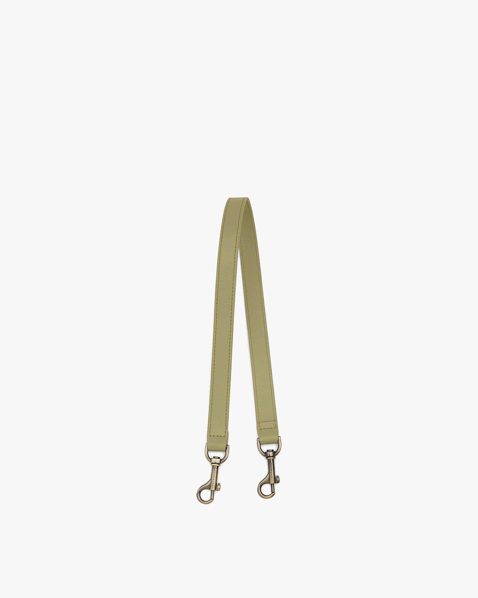 Short strap in leather, Limestone color, laid flat in a U shape, aged brass clasps visible