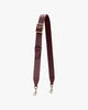 Bandoulière ajustable large en cuir aubergine, posée à plat, boucle laiton et mousquetons gravés
