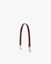 Short strap Marbre in leather, laid flat in an arch, aged brass clasps at both ends