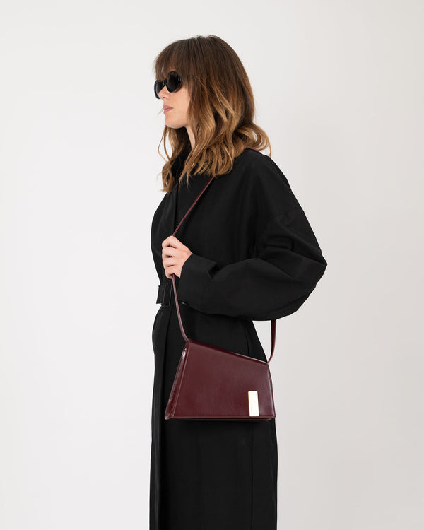 Sac TARA Mahogany porté en bandoulière, vue de profil sur un modèle en robe noire