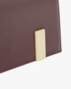 Sac TARA Mahogany, détail du fermoir rectangulaire doré gravé sur cuir bordeaux