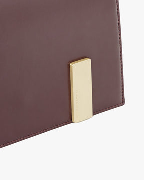 Sac TARA Mahogany, détail du fermoir rectangulaire doré gravé sur cuir bordeaux