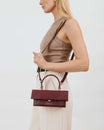 Sac THEA MINI Bordeaux embossé lézard porté en bandoulière, vue de profil sur modèle