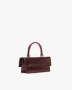 THEA MINI bag in Mahogany, side view, placed down, flap closed with top handle raised