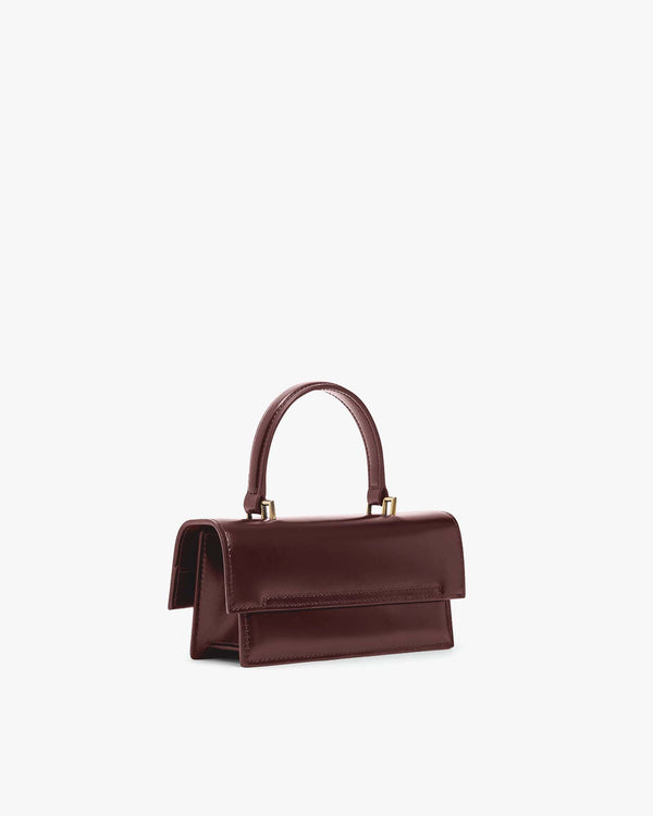 Sac THEA MINI Mahogany vu de profil, posé, rabat fermé et anse supérieure relevée