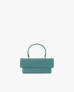 THEA MINI bag in turquoise, front view, flap closed, standing, with short top handle