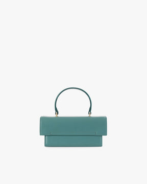 THEA MINI bag in turquoise, front view, flap closed, standing, with short top handle