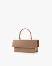 THEA bag in Beige, three-quarter view, closed flap, rigid handle, placed on white background