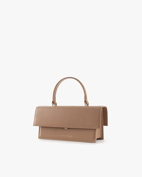 THEA bag in Beige, three-quarter view, closed flap, rigid handle, placed on white background