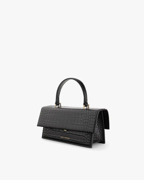 Sac THEA noir embossé crocodile, vue de trois quarts, poignée rigide, rabat oversize fermé