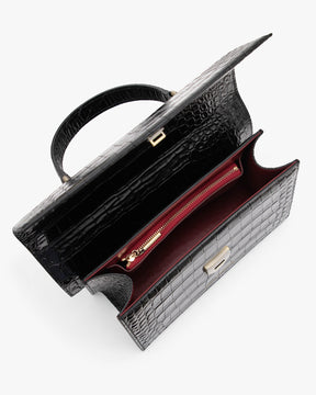 Sac THEA noir embossé crocodile, vue intérieure ouverte, poche zippée rouge et poignée rigide