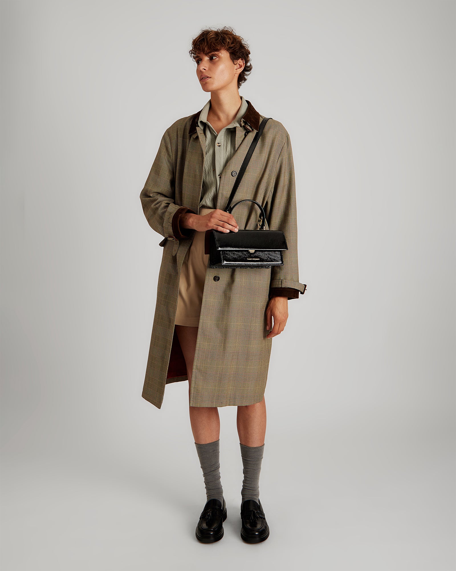 Sac THEA noir naplak porté en bandoulière, poignée rigide, sur mannequin tenue trench