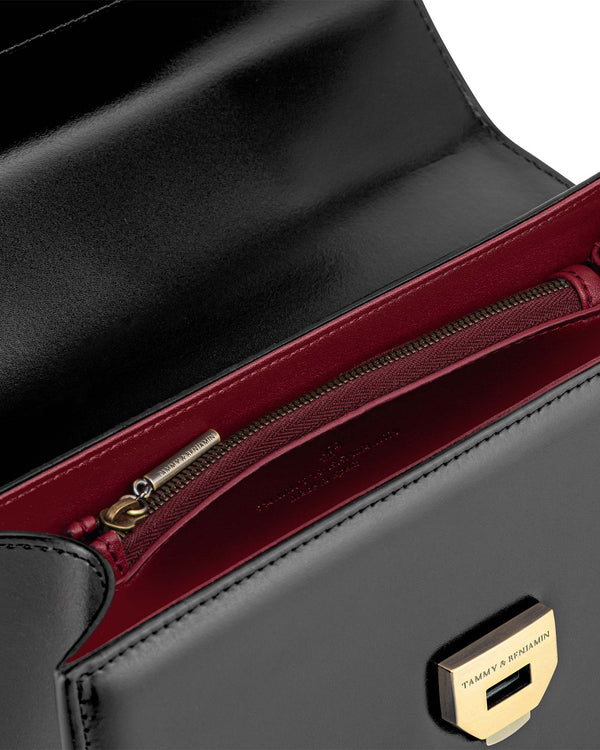 Sac THEA noir, vue intérieure sur doublure bordeaux, poche zippée et fermoir doré gravé