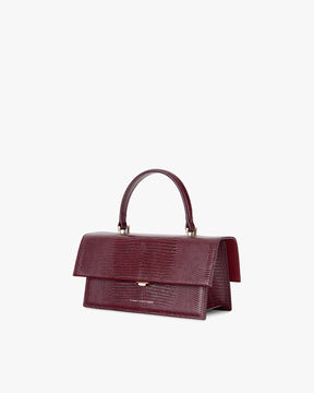 Sac THEA Bordeaux embossé lézard, vue de trois-quarts, rabat fermé, poignée rigide relevée