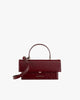 Sac THEA en cuir naplak bordeaux, vue de face, posé, avec rabat oversize et poignée rigide