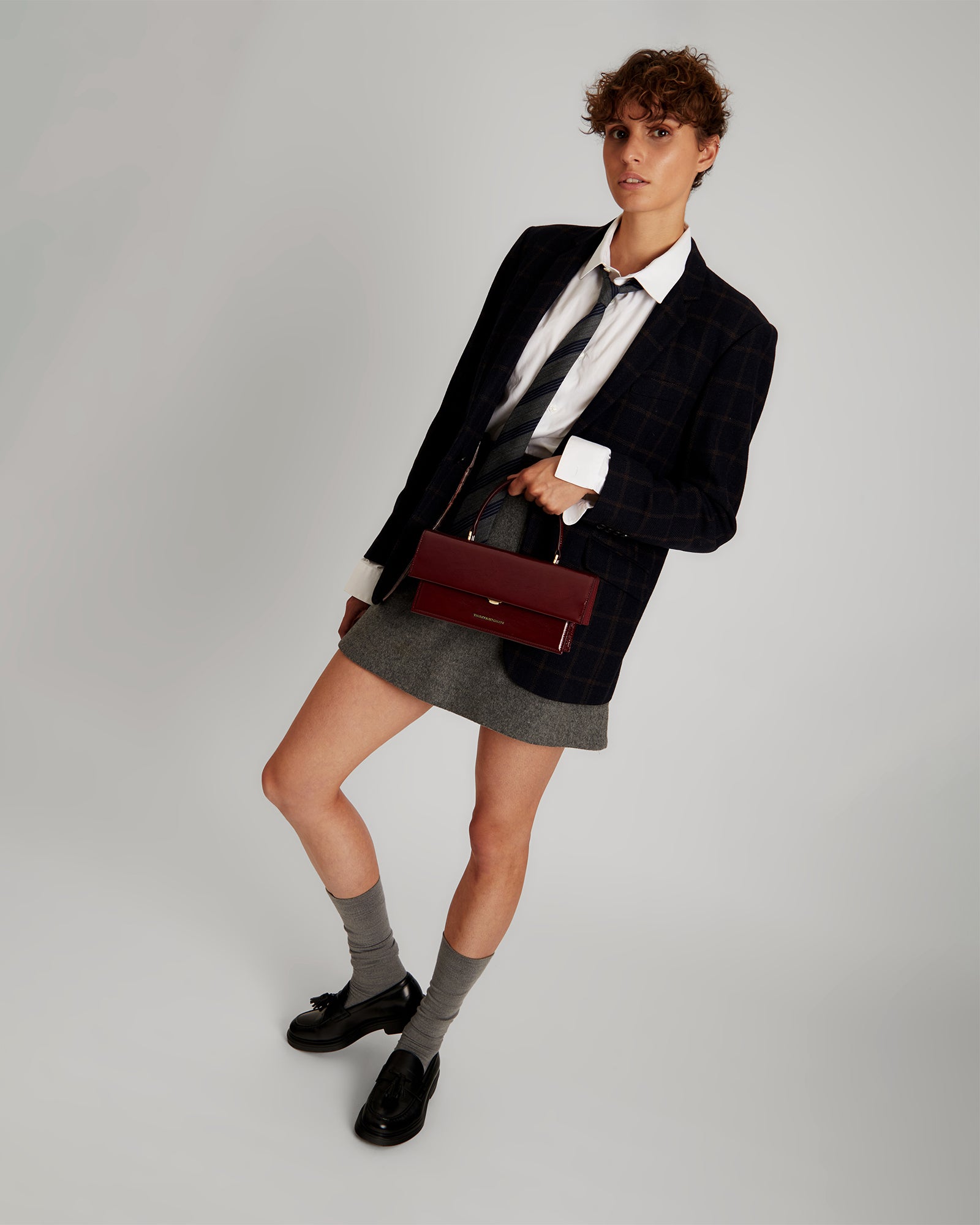 Sac THEA Bordeaux naplak porté à la main, mannequin de face avec tenue chic
