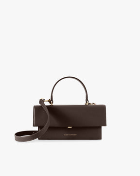 Sac THEA Chocolat de face, rabat fermé, posé avec poignée rigide et bandoulière détachée