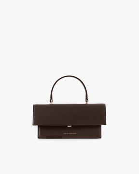 Sac THEA Chocolat de face, rabat oversize fermé, poignée rigide, posé sur fond blanc