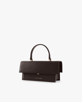 Sac THEA Chocolat de trois quarts, rabat fermé, poignée rigide tenue haute, fond blanc