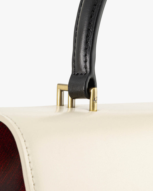 Sac THEA Colourblock art déco, détail de l'anse en cuir noir et de son fermoir à trois pitons dorés