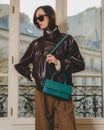 Sac THEA turquoise porté en bandoulière, poignée rigide, vue de face sur un mannequin