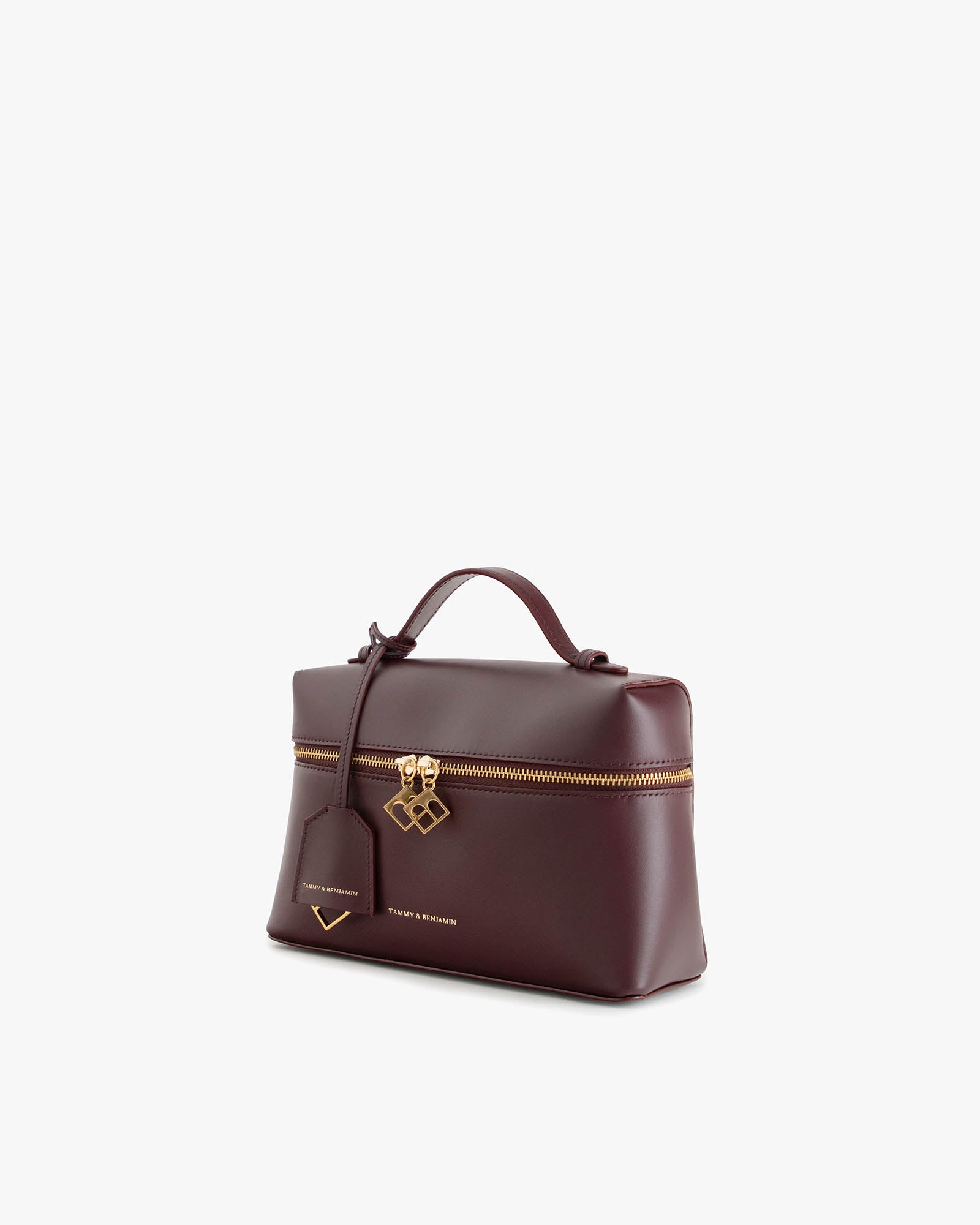 Sac VAYA Aubergine en cuir, vue de trois quarts, anse portée à la main, fermeture zippée et breloque Key Bell