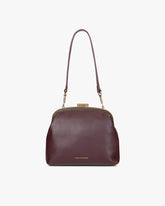 Sac EMMA Aubergine de face, porté en bandoulière avec anse longue, fermoir doré visible