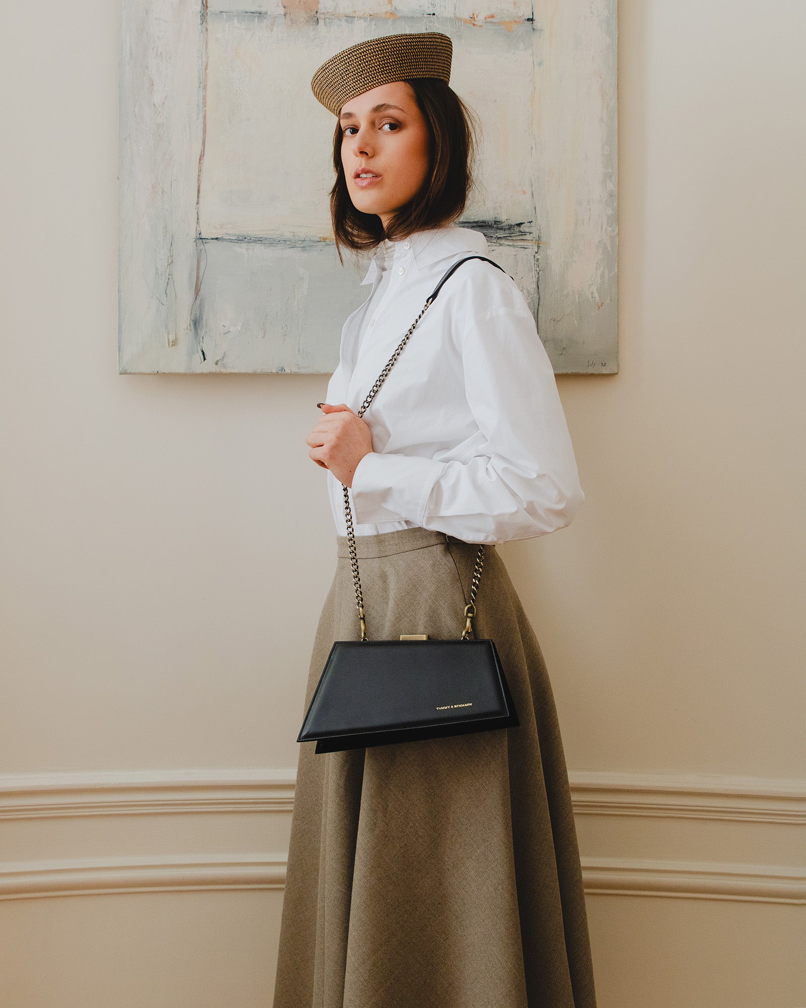 Sac JAY noir porté en bandoulière avec chaîne, vue de profil sur mannequin