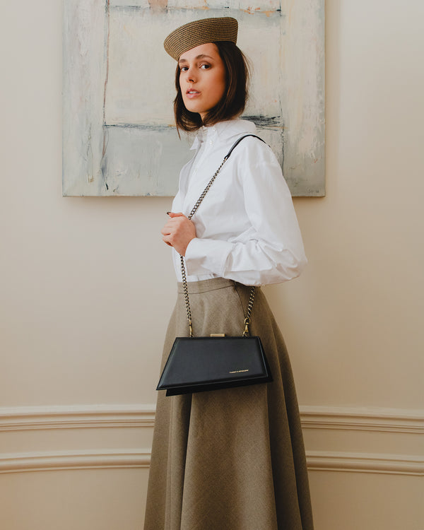 Sac JAY noir porté en bandoulière avec chaîne, vue de profil sur mannequin