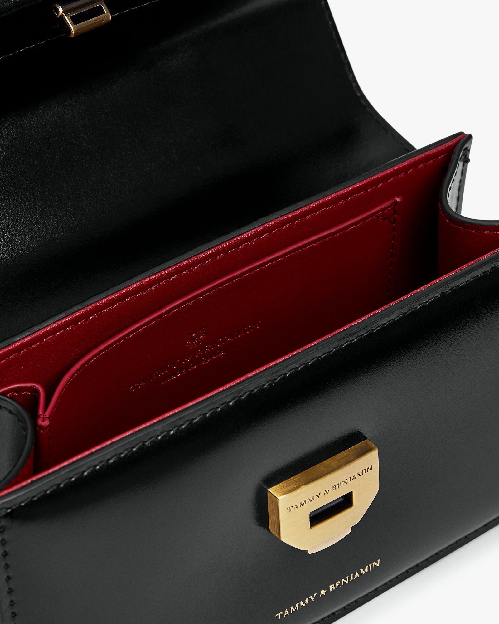 Sac THEA MINI noir, vue intérieure ouverte, rabat sur fermoir doré et doublure rouge