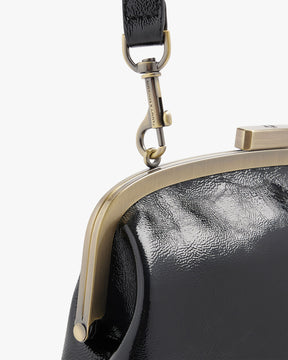 EMMA bag in black naplak, close-up of the metal clasp and shoulder strap hook