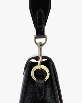 GABRIELLE bag in black naplak leather, close-up on the bronze clasp and engraved Tammy & Benjamin ring