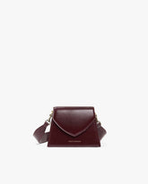 Sac GABRIELLE Mahogany, vue de face, posé, rabat en pointe et bandoulière ajustable