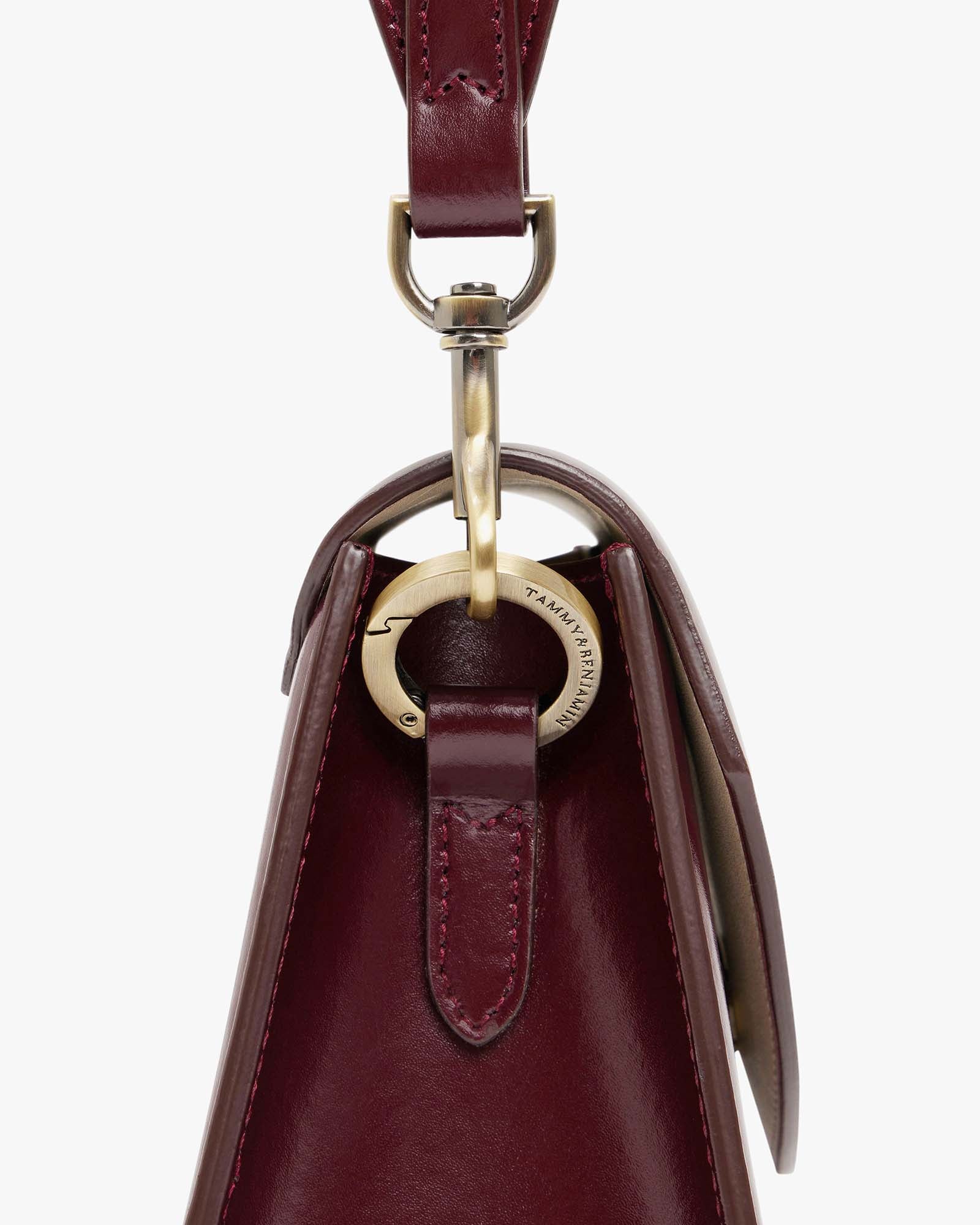 Sac GABRIELLE Mahogany, détail du fermoir mousqueton gravé et de l'anse en cuir