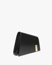 Sac TARA noir, vue de profil, posé, rabat fermé et fermoir doré rectangulaire