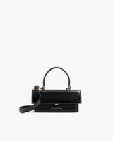 THEA MINI bag in black naplak, front view, standing, with top handle and detachable strap unclipped