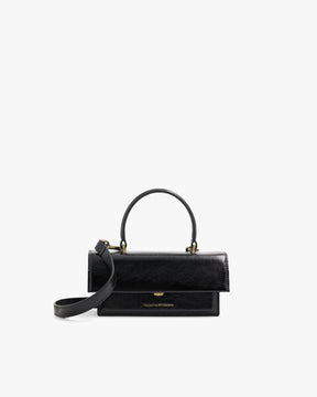 THEA MINI bag in black naplak, front view, standing, with top handle and detachable strap unclipped