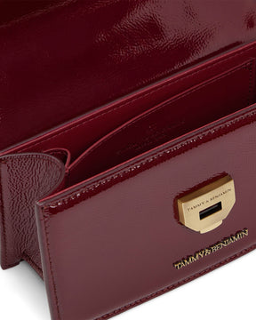 THEA MINI bag in Bordeaux naplak, close-up of the open flap and engraved gold clasp