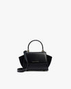 Sac ALEXIA NANO noir de face, rabat fermé, poignée rigide relevée, bandoulière amovible fixée