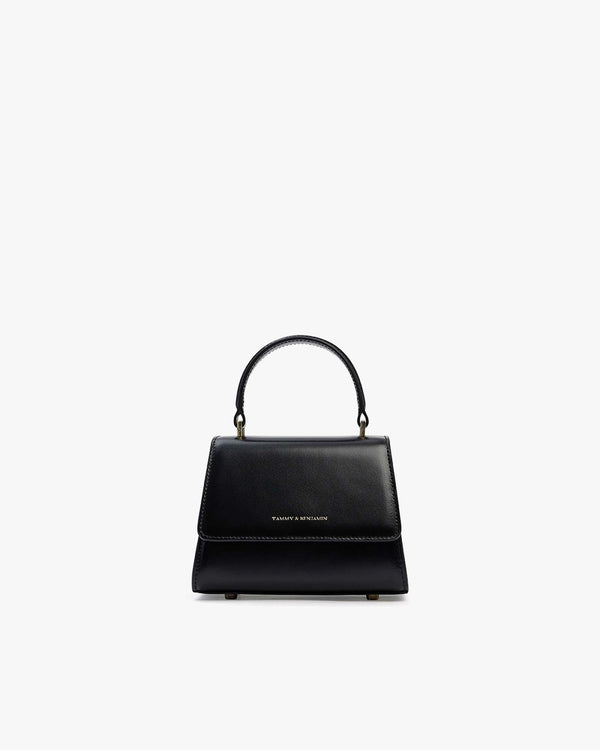 Sac ALEXIA NANO noir, vue de face, poignée rigide relevée, posé sur fond blanc