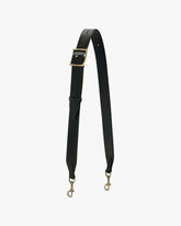 Bandoulière ajustable large en cuir noir, boucle laiton vieilli, posée en forme de V, mousquetons visibles