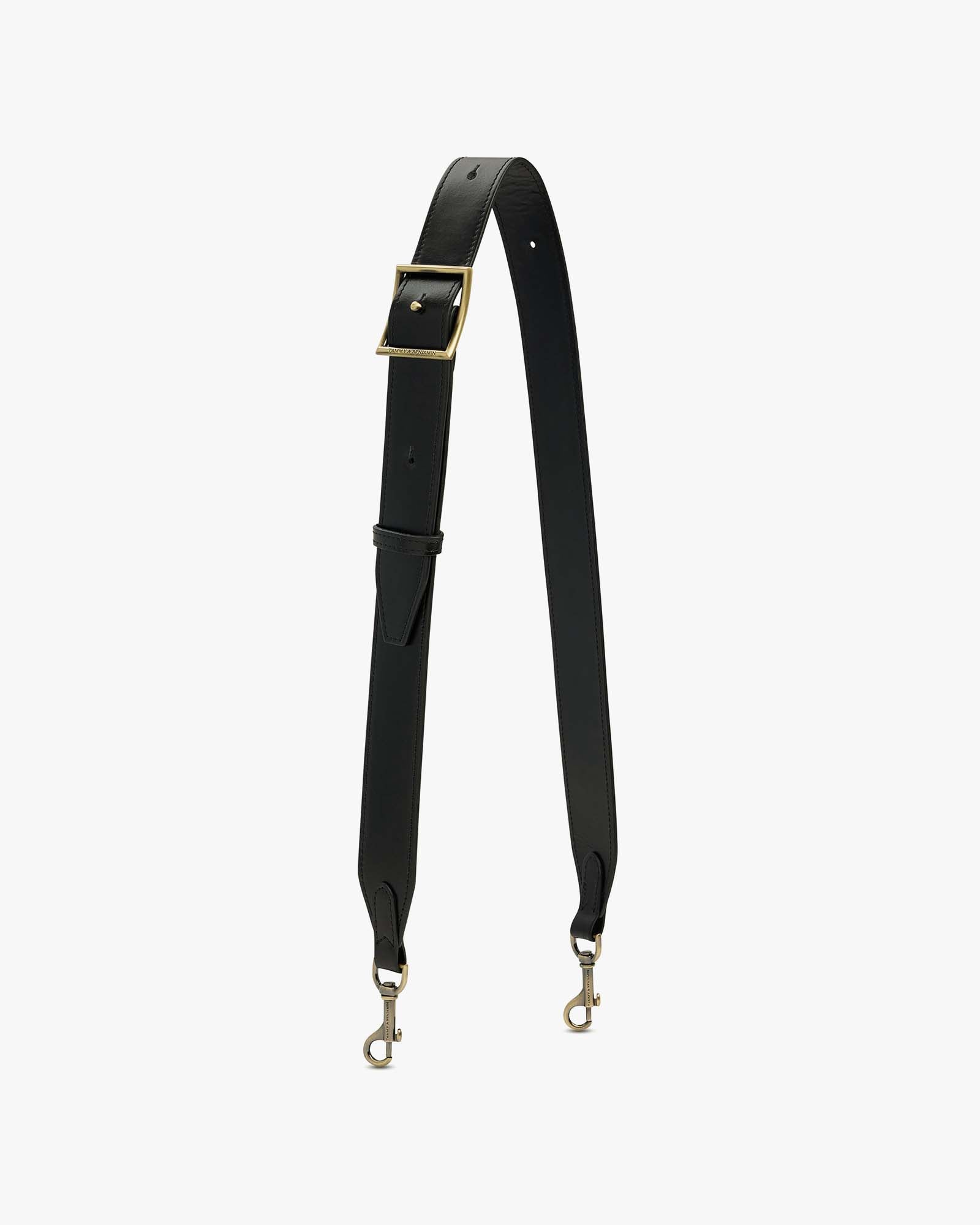 Bandoulière ajustable large Tammy & Benjamin en cuir noir, posée à plat, boucle et mousquetons en laiton vieilli