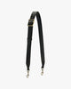 Bandoulière ajustable large en cuir noir, boucle laiton vieilli, posée en forme de V, mousquetons visibles