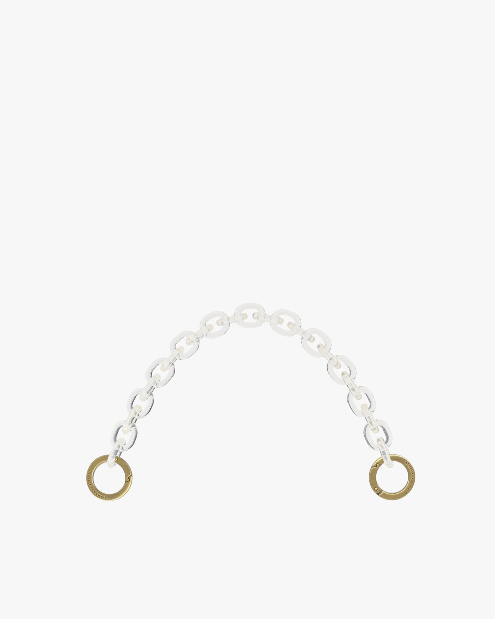 Short chain in clear resin, laid flat, engraved aged brass rings at both ends