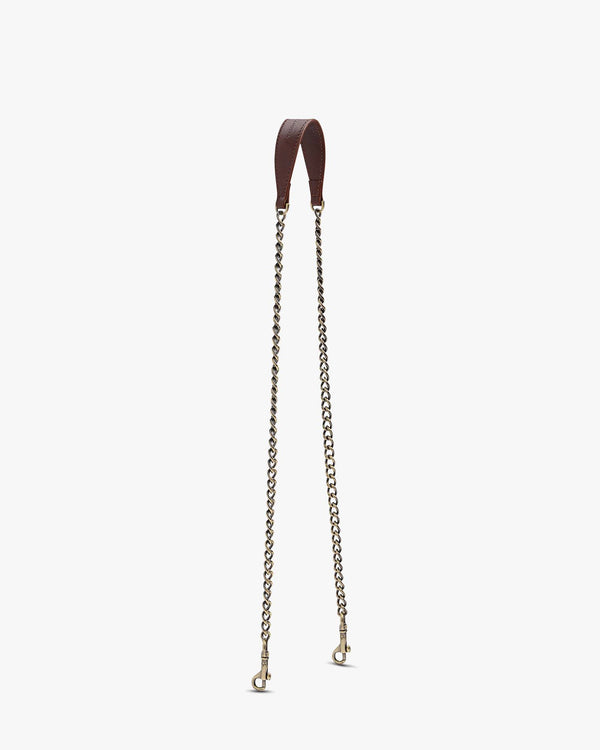 Long brown chain, leather tab with aged brass clasps, laid flat on white background