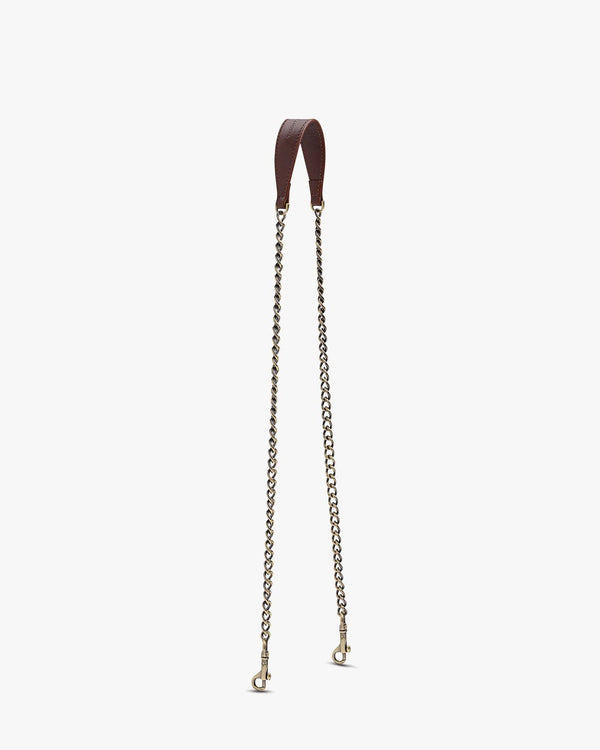Brown long chain, leather shoulder pad, two aged brass clasps, laid flat