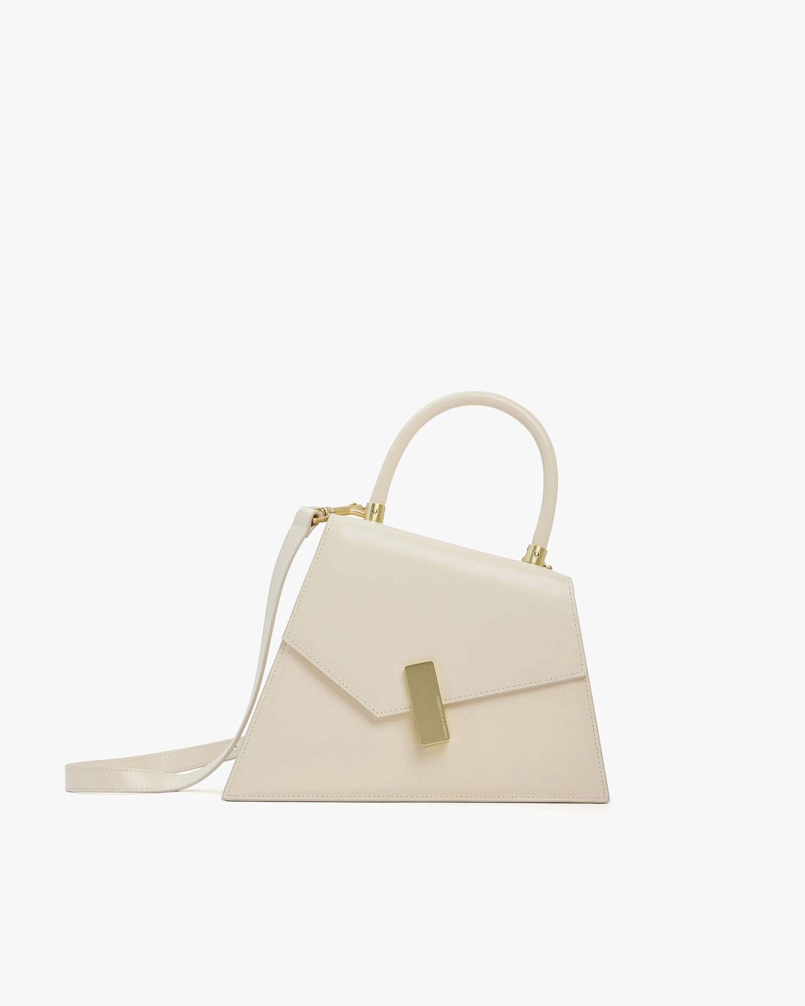 CUBIST bag in Ivory, side view, asymmetric shape, gold clasp, structured handle and thin strap