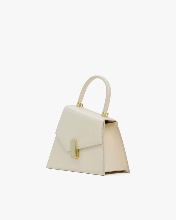 Sac CUBIST Ivoire vu de profil, silhouette asymétrique, fermoir doré rectangulaire et poignée relevée
