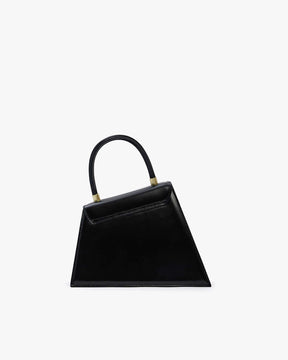 Sac CUBIST noir, vue de face, silhouette trapézoïdale asymétrique, anse ronde et fermoirs dorés