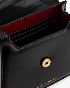 Sac GABRIELLE noir, vue intérieure sur le porte-cartes et le fermoir bouton doré